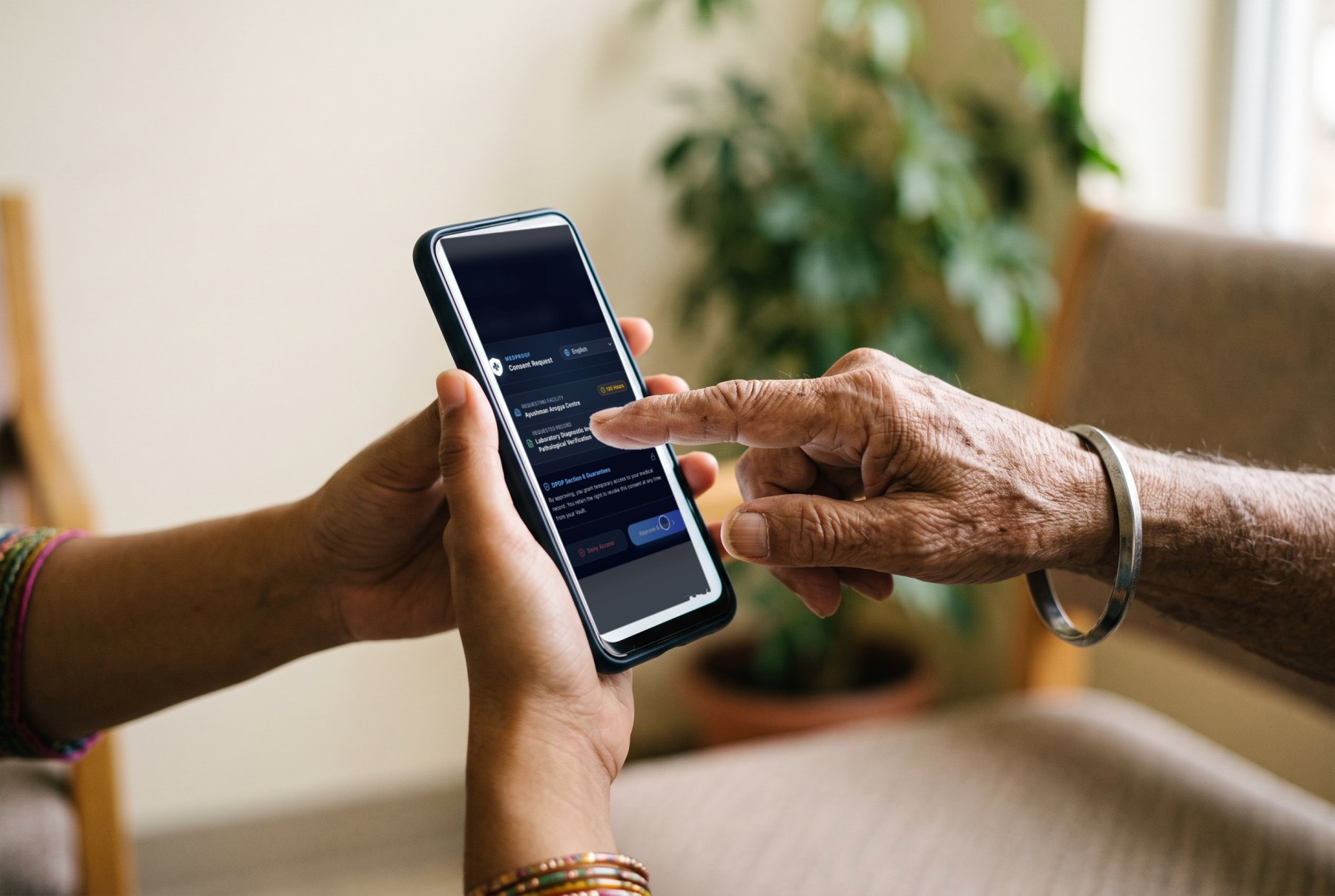 A younger hand holding a phone for an older hand to tap